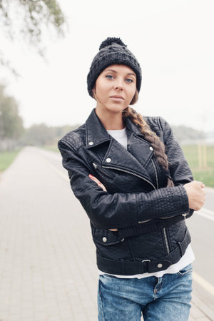 portrait of a beautiful young hipster girl in black hat. Outdoor lifestyle portrait of womanの写真素材
