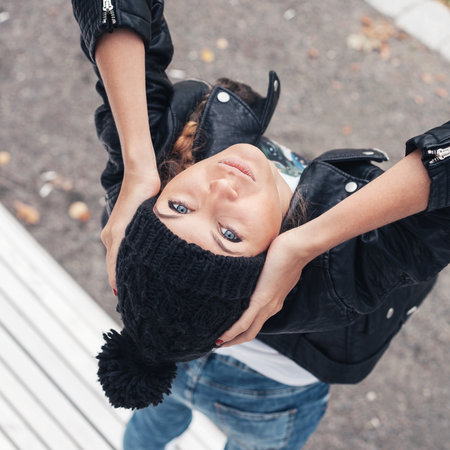 Young woman standing on a white bench in the park. View from above. Outdoors lifestyle portrait of girlの写真素材