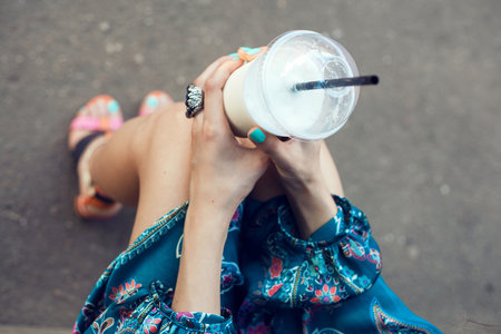 Girl with glasses drinking milkshake. Outdoor lifestyle portrait of womanの写真素材