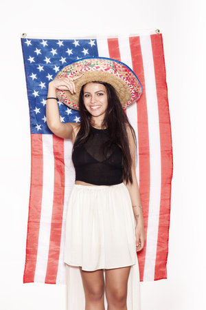 Portrait of a young Latina woman in sambrevo on the background of the American flag. Portrait of girl on white background, not isolatedの写真素材