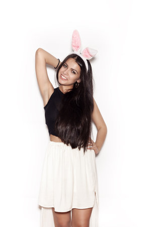 Young girl in pink bunny ears. Sweet woman having fun on white background, not isolatedの写真素材