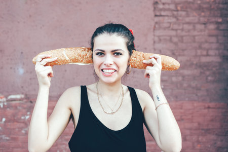 Woman fooling around bread. Outdoor lifestyle portraitの写真素材