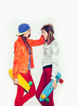 Two young girl friends standing having fun together.  Beautiful woman opening Mouth. Emotion.  Hairstyle. Makeup.  White background, not isolatedの写真素材