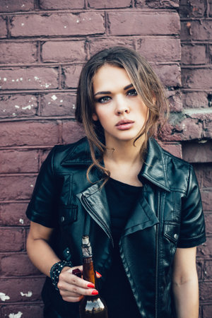 Pretty girl with Molotov cocktail bomb in her hand.  Outdoor lifestyle portraitの写真素材