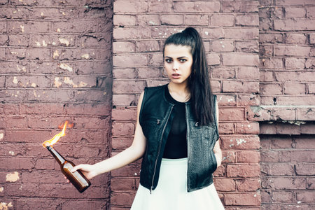 Bad girl with Molotov cocktail bomb in her hand.  Outdoor lifestyle portraitの写真素材