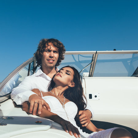 Young couple loving each other. Sexy man and woman relaxing on a sea voyage on a yachtの写真素材