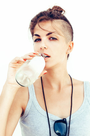 Young pretty brunette girl in sunglasses  Beautiful woman drinking water in spring day. Outdoor summer portraitの写真素材