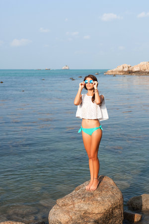 Girl standing on coastal sea rocks. Well being healthy lifestyleの写真素材