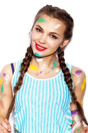 Young cheerful soiled in paint girl having fun. Woman with bright makeup and hairstyle with pigtails. White background not isolatedの写真素材