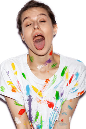 Young cheerful soiled in paint girl having funの写真素材