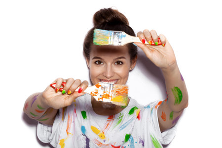 Young cheerful soiled in paint girl having funの写真素材