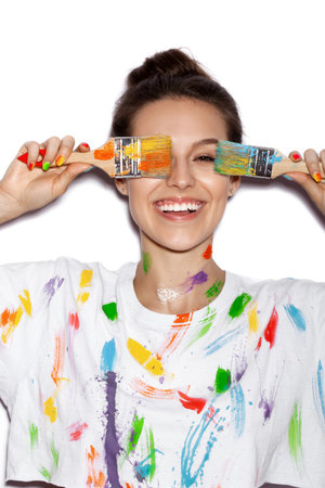 Young cheerful soiled in paint girl having funの写真素材