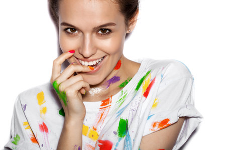 Young cheerful soiled in paint girl having funの写真素材
