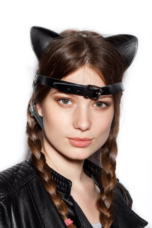 Young pretty woman with leather cat ears. White background not isolated. Indoor lifestyle portrait of girlの写真素材