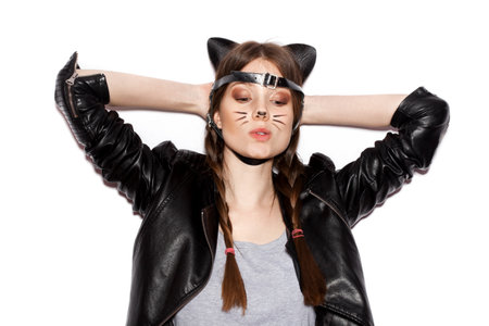 Funny girl represents as small cat.  Woman  with bright makeup hairstyle of girl with leather cat ears having fun. On white background not isolatedの写真素材