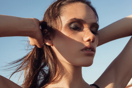 Beauty Sunshine Girl Portrait. Pretty happy woman enjoying summer outdoors. Sunny Summer Day under the Hot Sunの写真素材