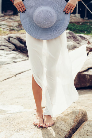 Young pretty woman in white dress on the sea. Outdoors lifestyle portraitの写真素材