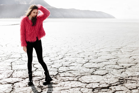 Young woman walking on dry land. Outdoors lifestyle portraitの写真素材
