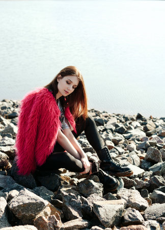 Beautiful young woman outdoors portrait near the lake. Soft sunny colorsの写真素材