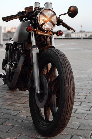 Close-up of vintage custom caferacer motorcycle in the parking lot during sunset. Stylish motorbike.  Outdoors lifestyleの写真素材