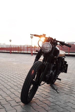 Vintage custom caferacer motorcycle in the parking lot during sunset. Stylish motorbike.  Outdoors lifestyleの写真素材