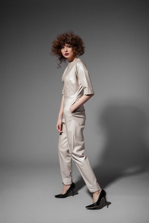 Fashion portrait of young sexy woman with hairstyle posing on grey backgroundの写真素材