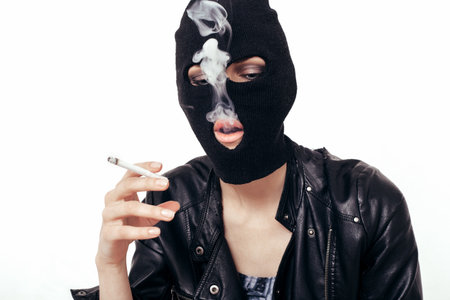 Cool girl in balaclava smoking cigarette