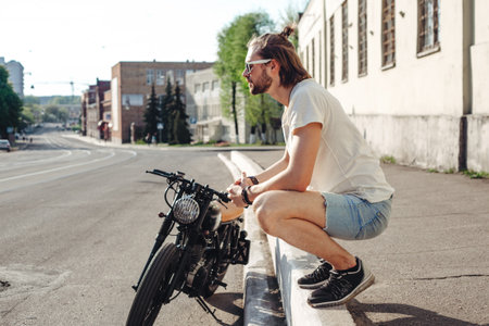 portrait young guy with a beard and mustache with sunglasses posing on the street vintage man,...