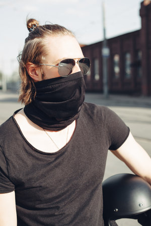 Biker in black t-shirt posing holding his helmetの写真素材
