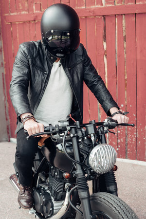Biker sitting on vintage custom motorcycle. Outdoor lifestyle portraitの写真素材
