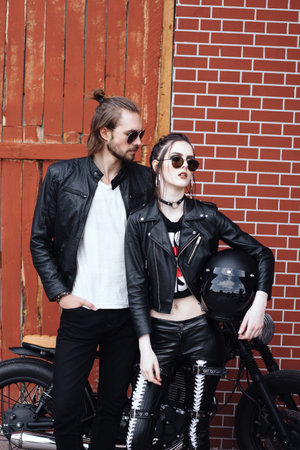 Couple in love. Bikers and vintage custom motorcycle. Outdoor lifestyle portraitの写真素材