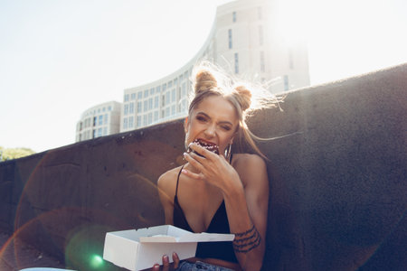 Portrait of hungry young cheeky girl eating donut