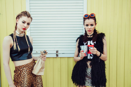 Young women drinking from a paper bag in the street. Outdoor girls portrait, Fashion modelsの写真素材