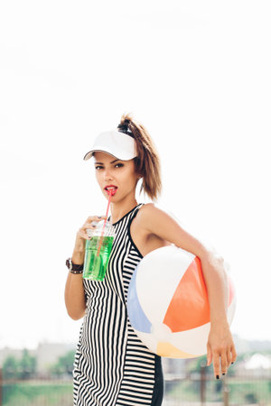 Outdoors portrait of a young sporty woman drinking an isotonic drinkの写真素材