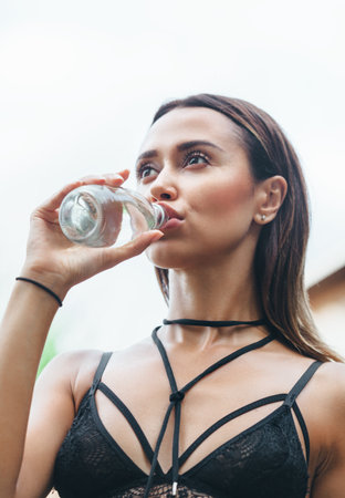 Portrait of a tanned woman drinking water. Summer vacationの写真素材