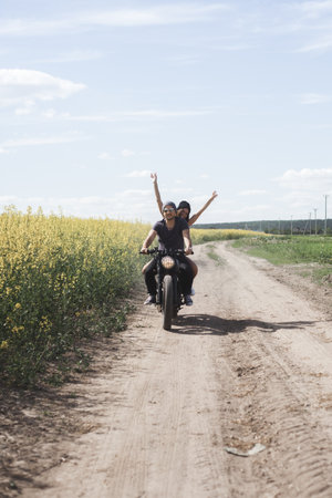 Young romantic couple in a field on a motorcycle.の写真素材