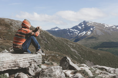 Guy taking pictures of the nature of Norway on the smartphoneの写真素材