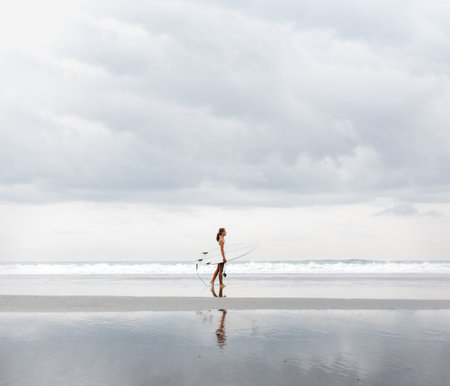 Girl in bikini with surfboard at a sand beachの写真素材