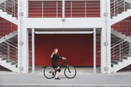Outdoor lifestyle portrait of pretty sexy young girl posing with street bicycleの写真素材