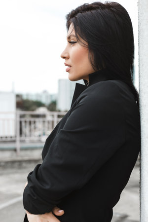 Side view of a Caucasian Businesswoman walking on city street in front of white wallの写真素材