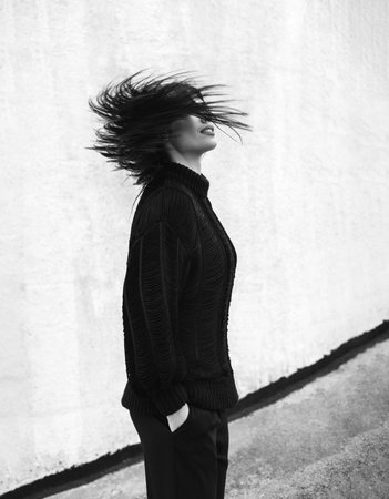 Young woman wearing woolen sweater walking in the autumn city streetの写真素材