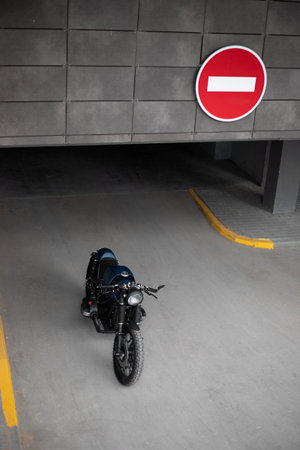 Black blue rebuilt vintage custom motorcycle cafe racer in front of wall