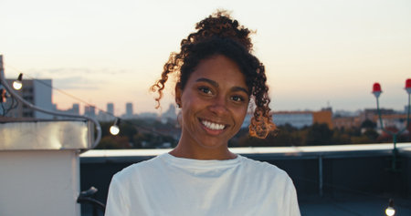 close up portrait of attractive black afro-american woman smiling brunette confident pretty at a rooftop partyの写真素材