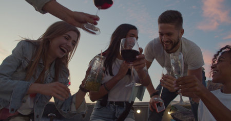 Friends Celebrating Birthday On Rooftop Terrace With City Skyline In Background . Young People Youth Freedom To Enjoy Life Conceptの写真素材