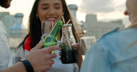 Group of happy friends toasting champagne, wine, beer, juice. Friendship concept with young people having fun together. Rooftop party birthdayの写真素材