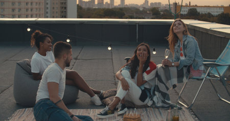 Friends Celebrating Birthday On Rooftop Terrace With City Skyline In Background . Young People Youth Freedom To Enjoy Life Conceptの写真素材