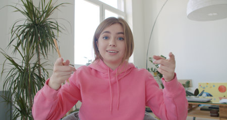 young woman working at home. Girl speaking looking at camera talking making video chat or conference...