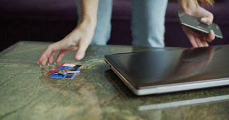 Girl taking laptop, notebook, cards and house keys from table. Female model late for work and...