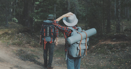 Young man and woman hiking in forest. Hiker camping in woods. Tourist couple walking by stream.の写真素材