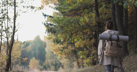 Active healthy female hipster model hiking along forest mountain road. Caucasian girl rest outdoors...